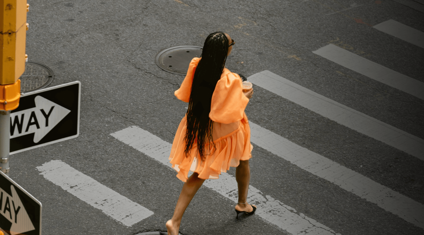 Woman in a yellow gold dress in the cross walk in New York City