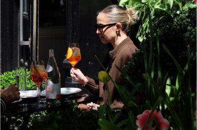 Woman enjoying a drink outdoors at Sartiano's Cafe