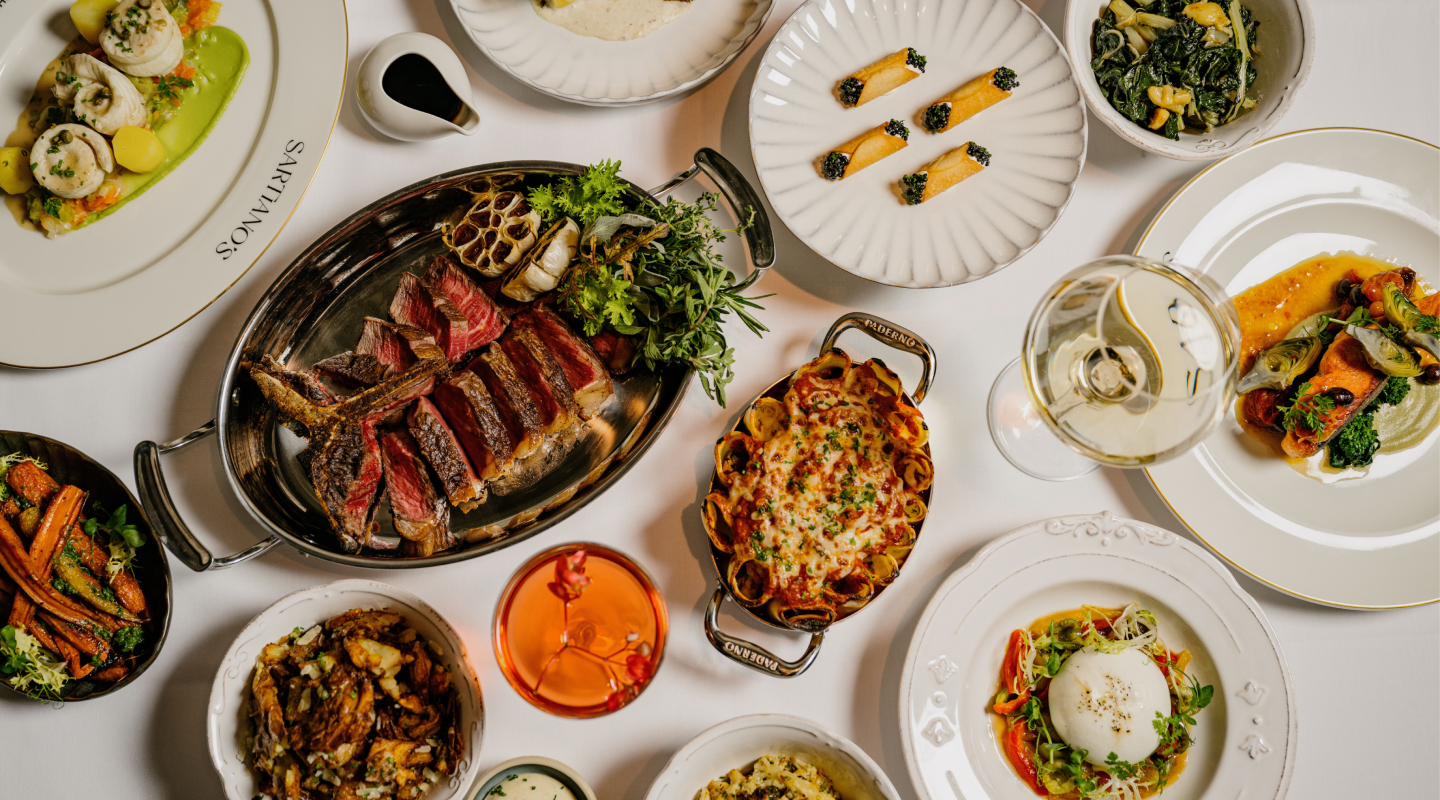 A family style table spread of dishes at Sartiano's